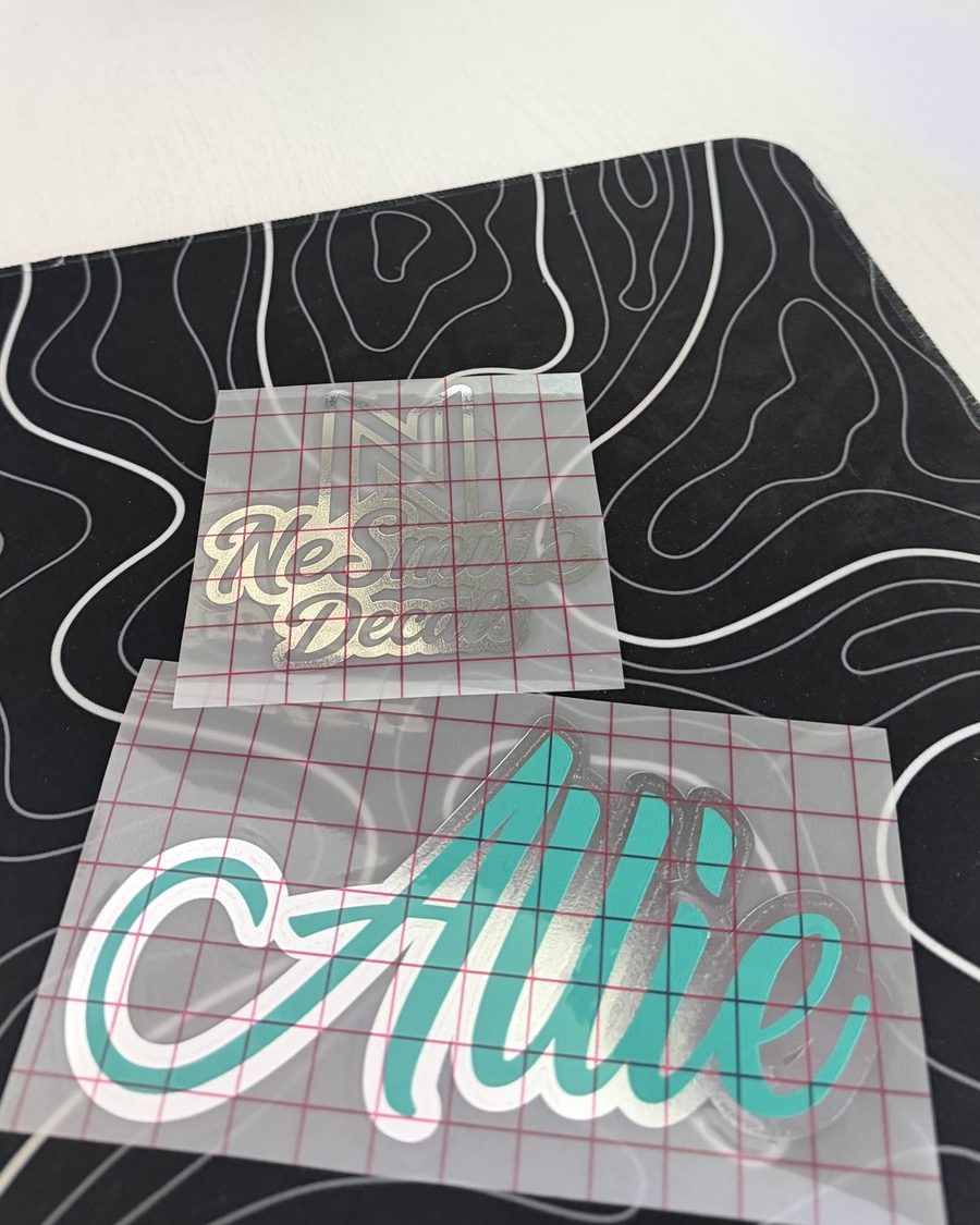 Teal script name decal with a white outline layer, on transfer tape