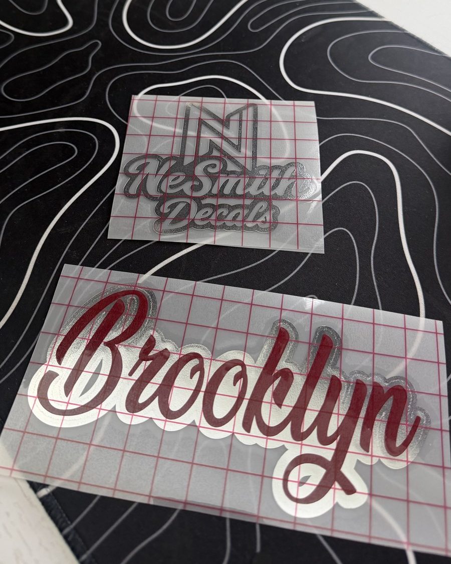 Burgundy script name decal with a white outline layer, on transfer tape