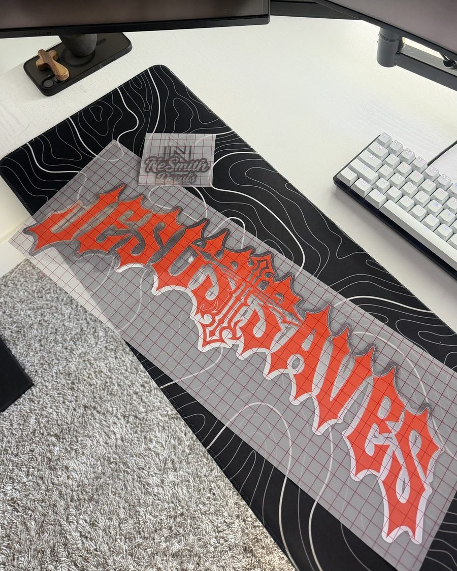 Red gothic lettering with an ornate cross and a white and chrome outline, on transfer tape