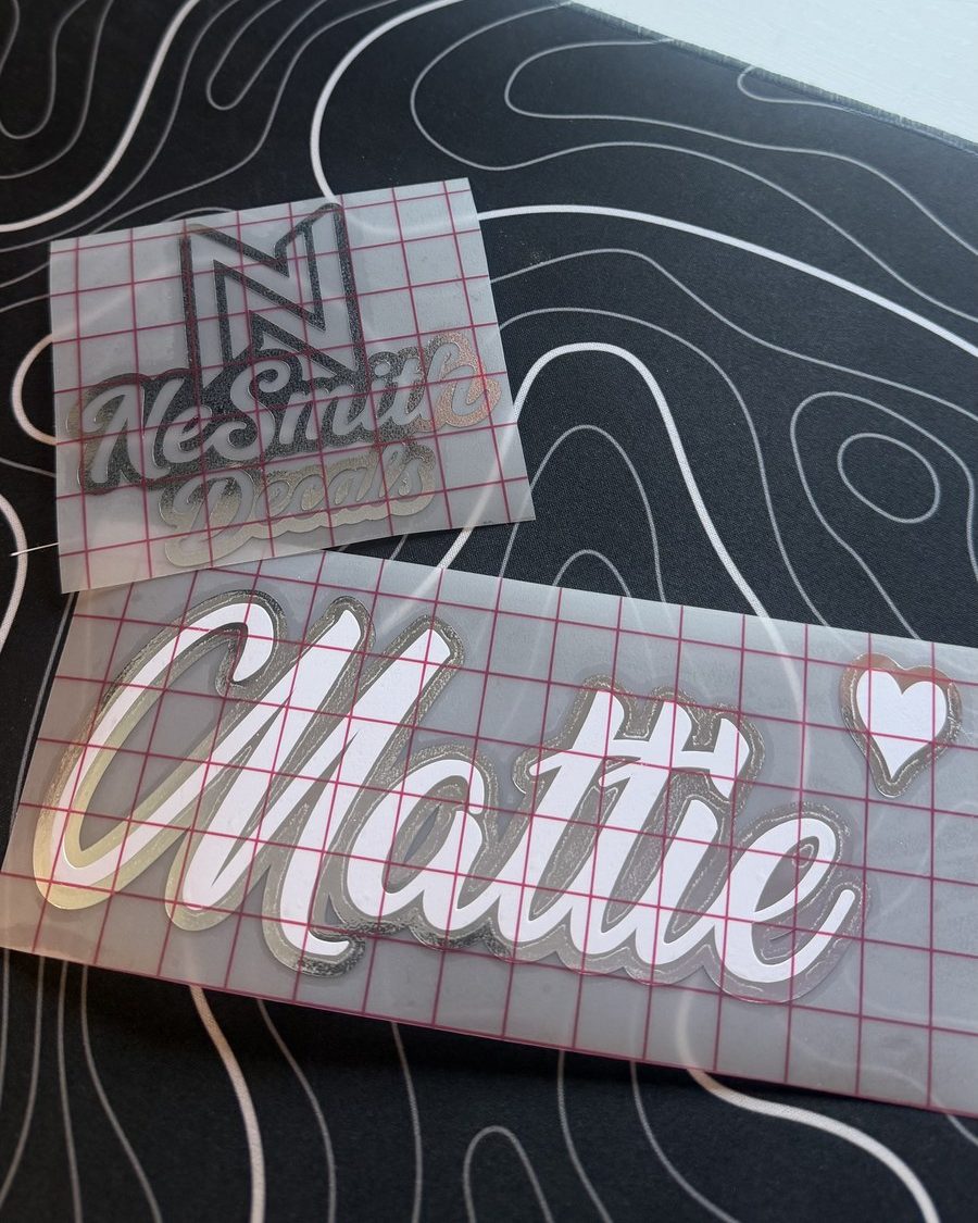 White script name decal with a chrome outline and a small heart, on transfer tape